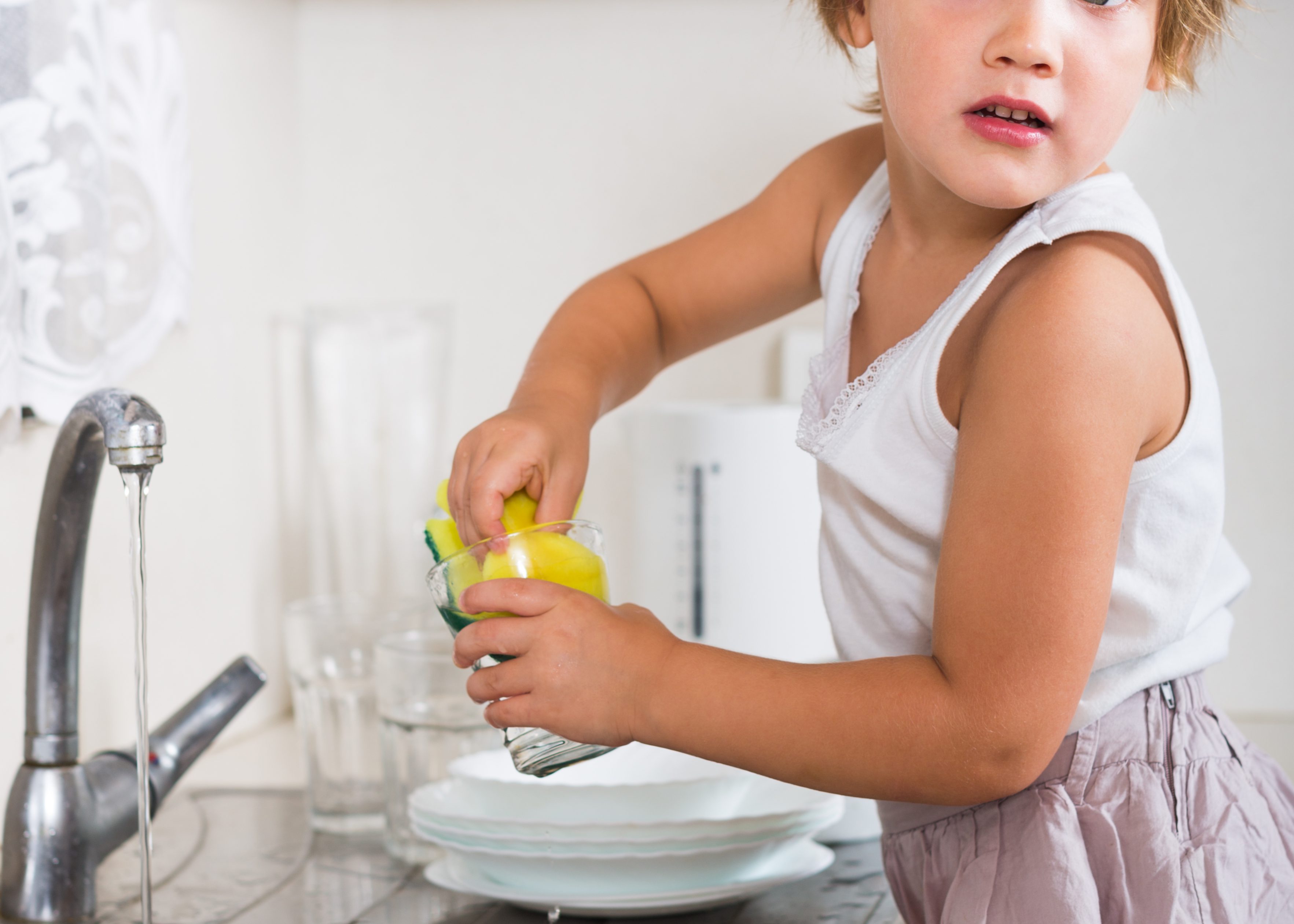 Small girl chores washing dishes